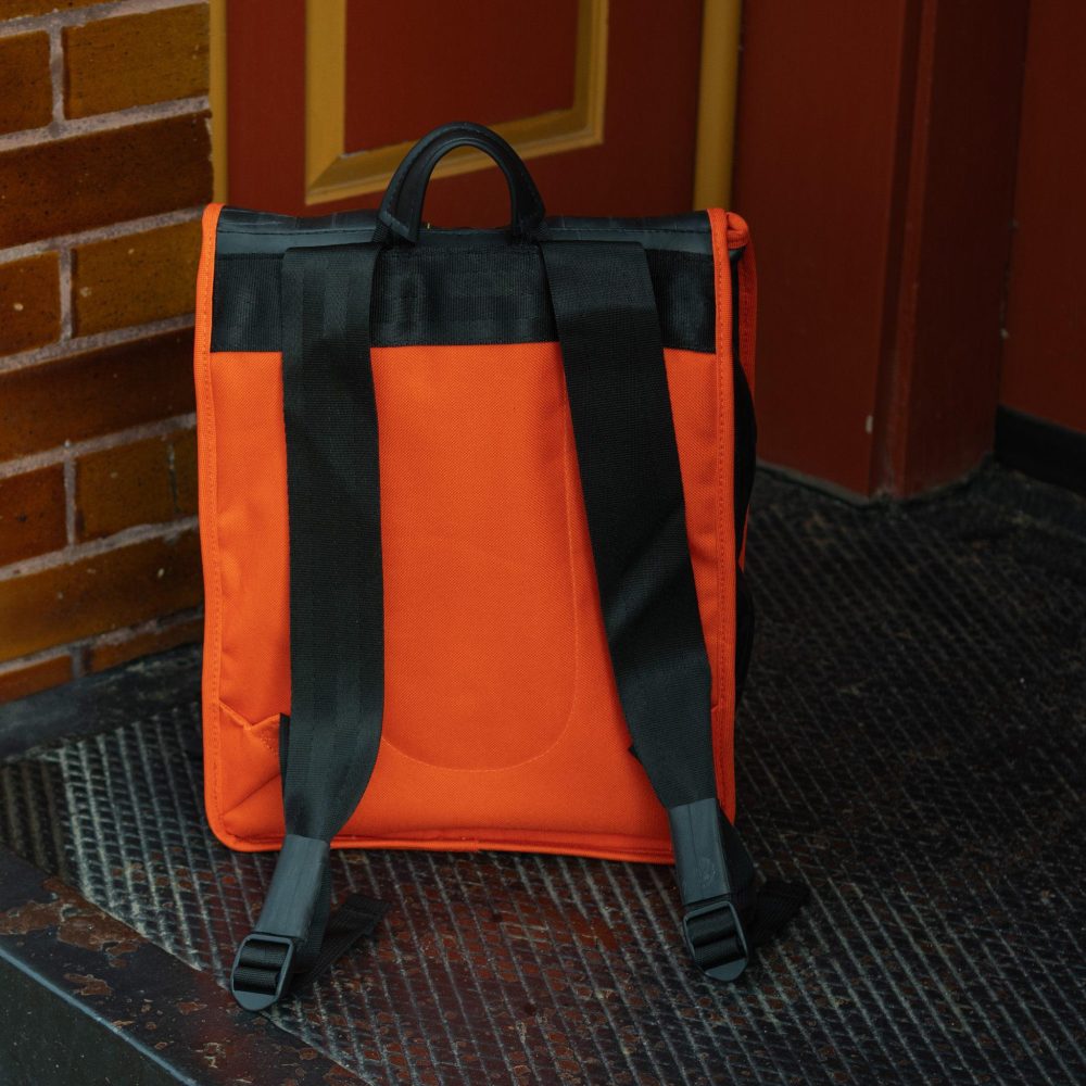 Madison Upcycled Backpack by Alchemy Goods. Black and mandarin back view.