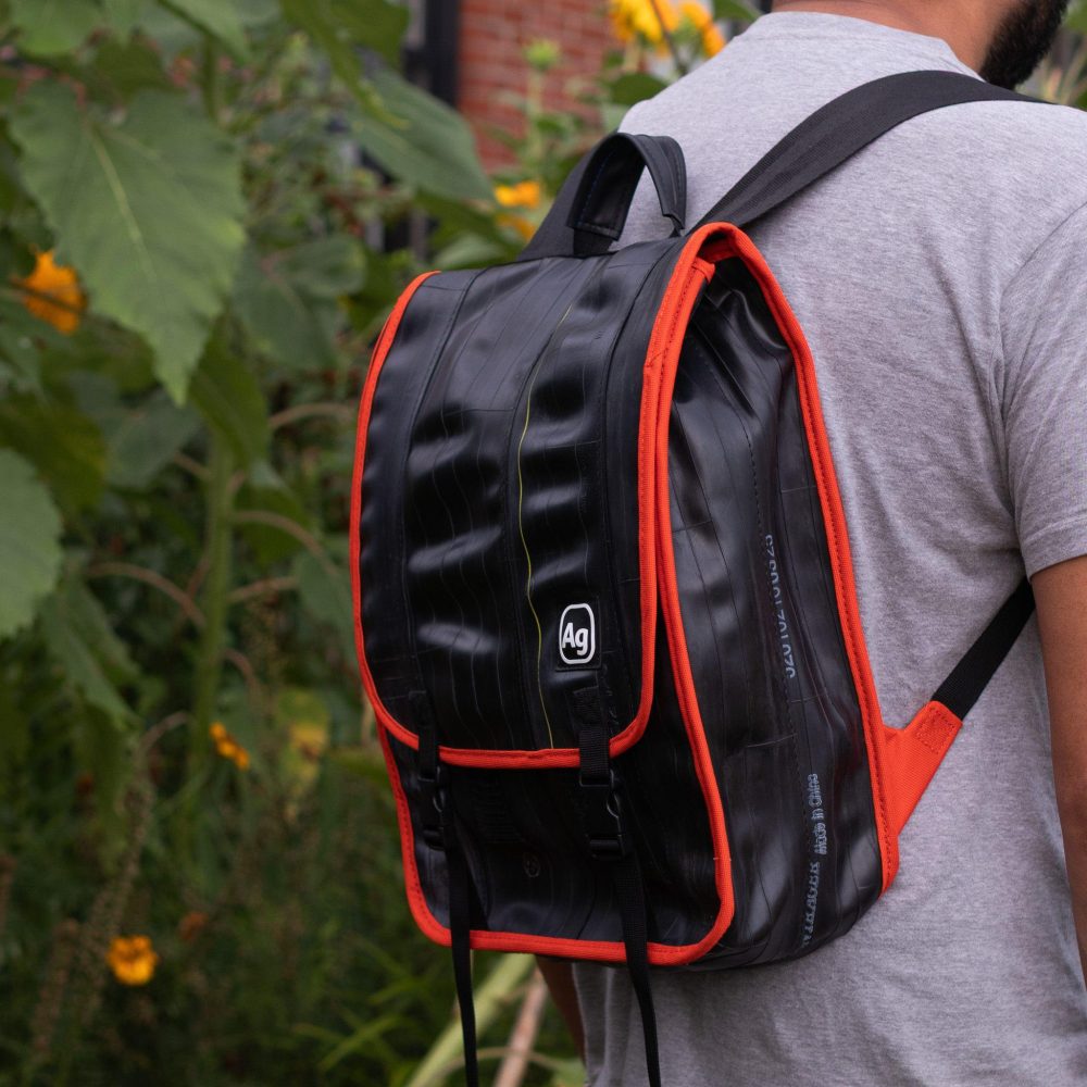 Madison Upcycled Backpack by Alchemy Goods. Black and Mandarin. Right worn view.
